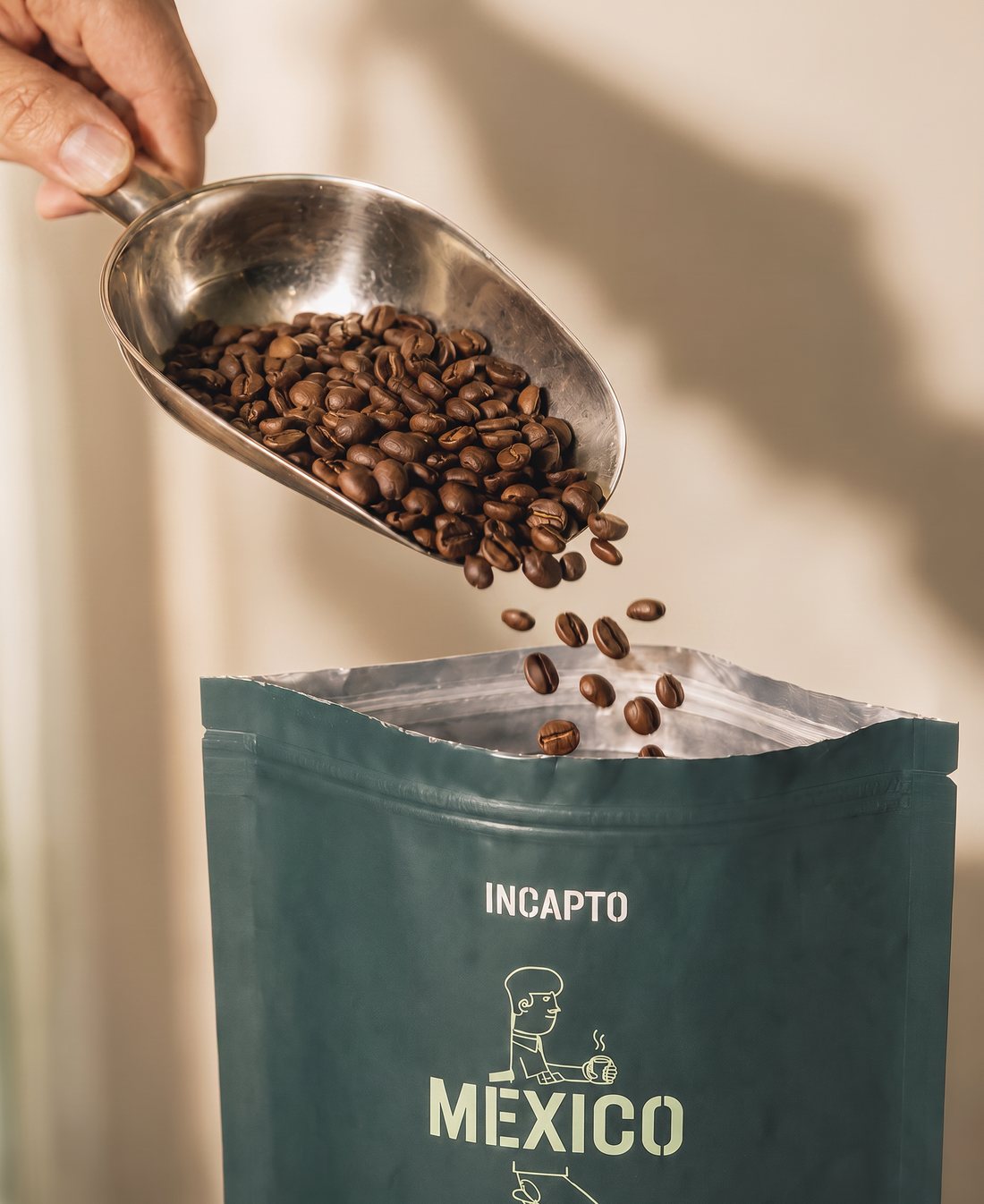 Granos de café en grano cayendo sobre un pack de café de origen México de INCAPTO