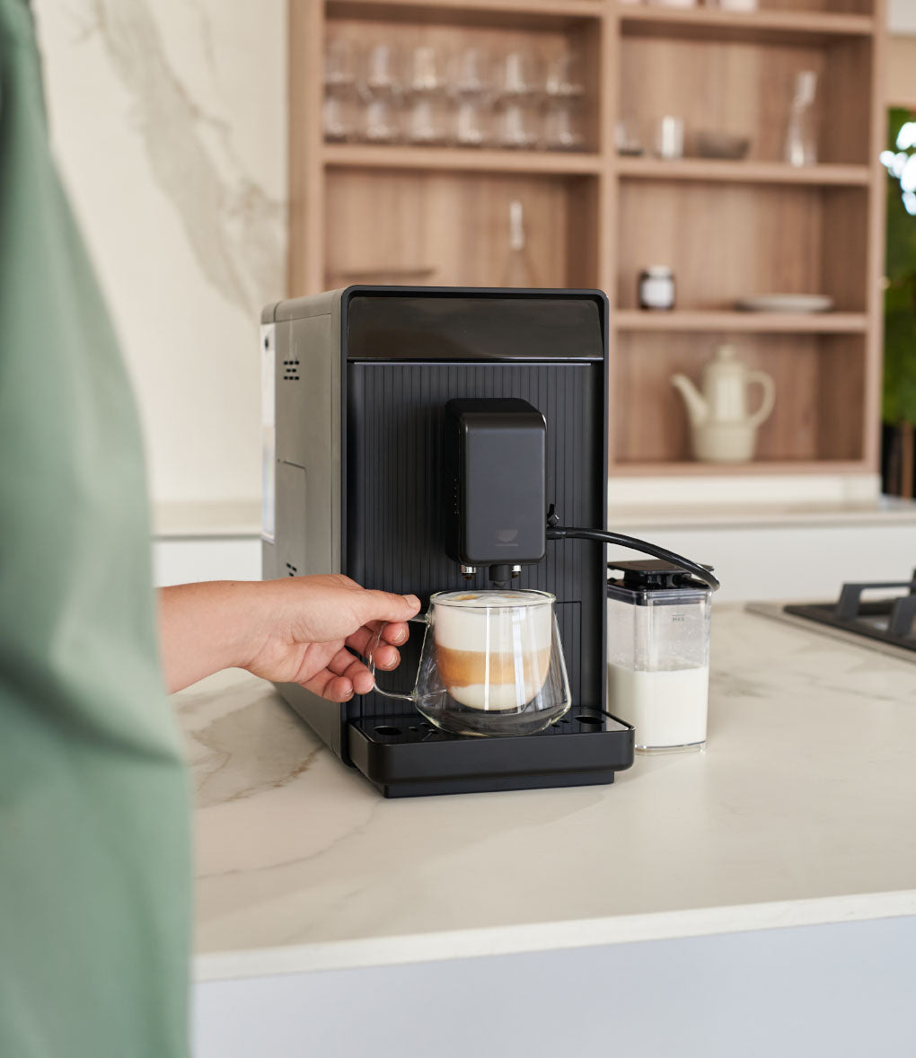 Donna che prende una tazza di caffè con cappuccino fresco