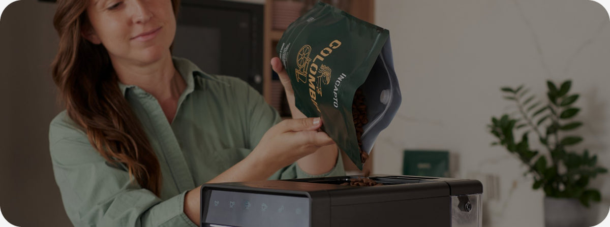Rellenando con café en grano la tolva de una cafetera INCAPTO en casa